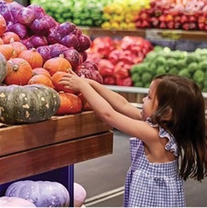 Girl picking a pumpkin at a grocer